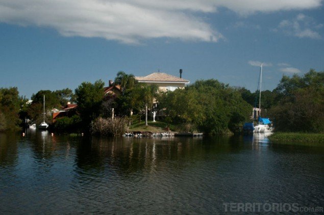 Houses on the riverside and their sail boats